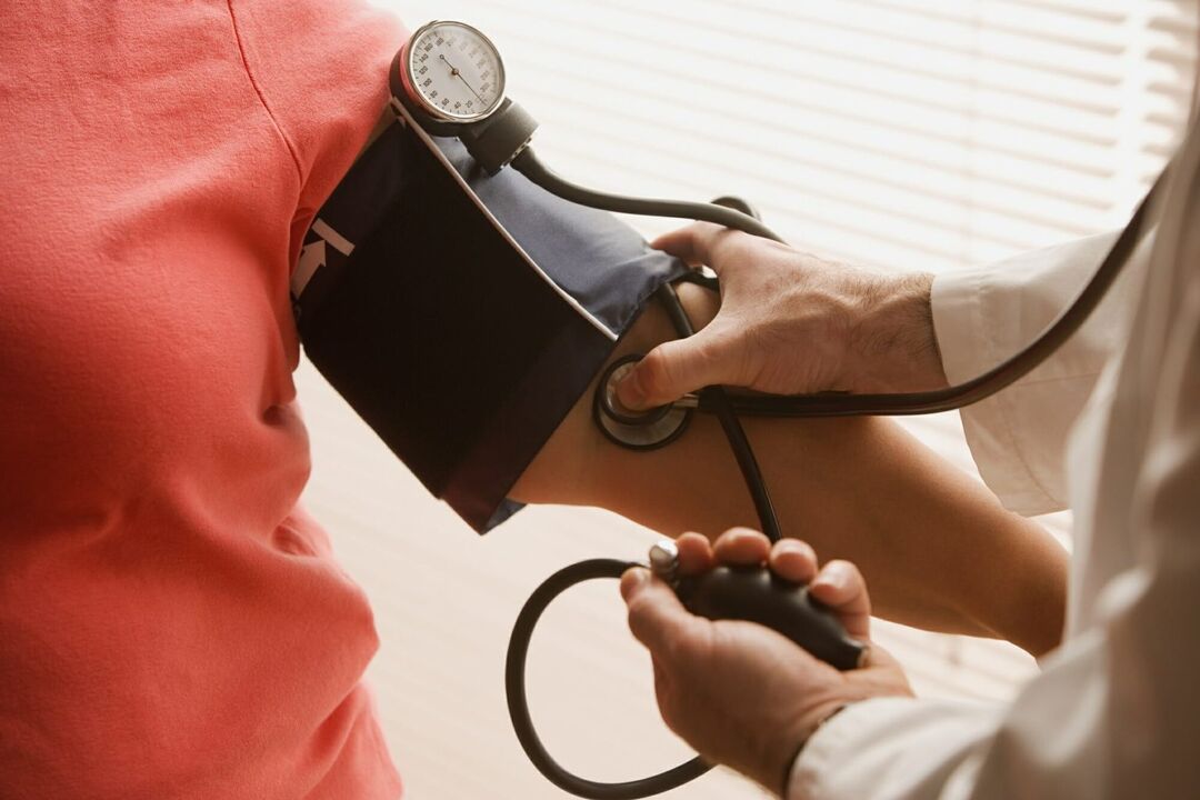 Il medico misura la pressione sanguigna di un paziente con ipertensione
