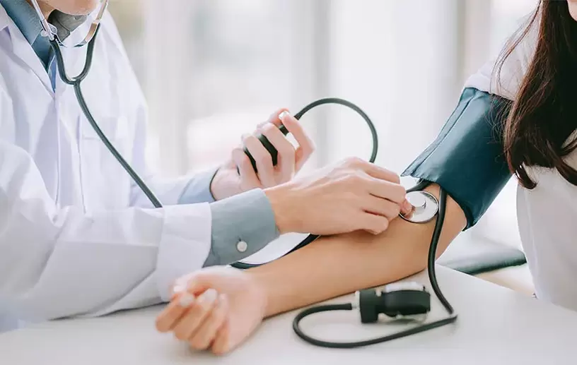 Un cardiologo misura la pressione sanguigna di un paziente per diagnosticare l'ipertensione. 